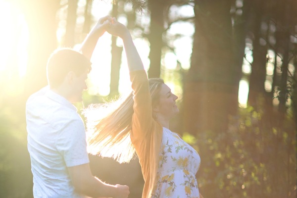 Jordan twirls Esther as they dance in the late afternoon, woodland sunshine